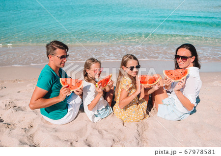 Happy family eating watermelon on the beach. 67978581
