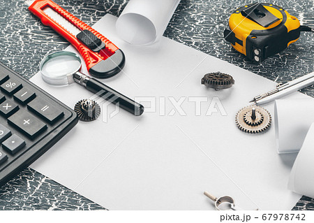 safety helmet and Scrolls of engineering drawings and supplies 67978742