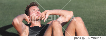 Fit man training at fitness gym doing situp crunches on exercise mat. Bodyweight floor exercises. Healthy and sport lifestyle. Man doing weight loss abs stomach exercise for ab muscles. Banner crop. 67980440