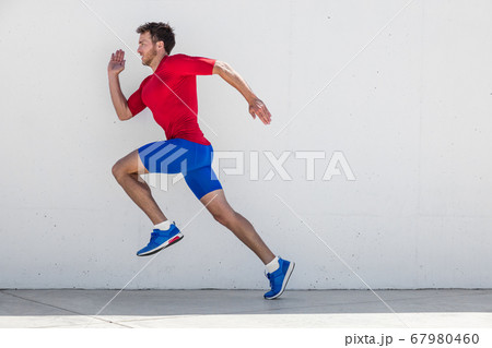 Running man runner training doing outdoor city run sprinting along wall background. Urban healthy active lifestyle. Male athlete doing sprint hiit high intensity interval training. Running man runner training doing outdoor city run sprinting along wall background. Urban healthy active lifestyle. Male athlete doing sprint hiit high intensity interval training. 67980460