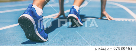Sprinter waiting for start of race on running tracks at outdoor stadium. Sport and fitness runner man athlete on blue run track with running shoes. Banner panorama. Sprinter waiting for start of race on running tracks at outdoor stadium. Sport and fitness runner man athlete on blue run track with running shoes. Banner panorama. 67980463