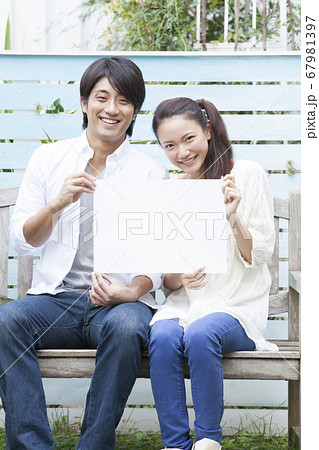 メッセージボードを持つ夫婦 67981397