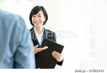 客に施設を案内するミドル女性 67982447