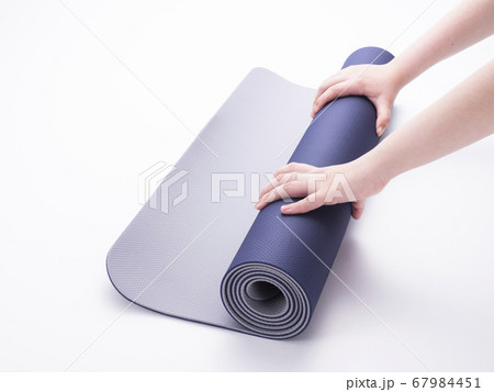 ヨガマットを丸める女性の手 67984451