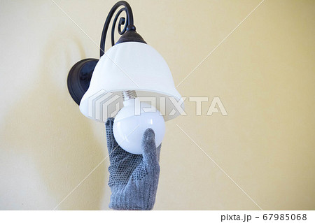 軍手をはめてする照明の電球交換作業	 67985068