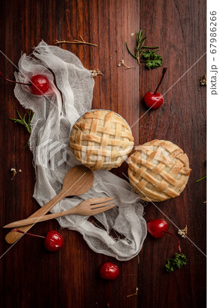 Mini coconut pie with red cherry on wooden table. Mini coconut pie with red cherry on wooden table. 67986266
