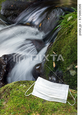 沢をバックに緑の苔の上のマスク 67986366