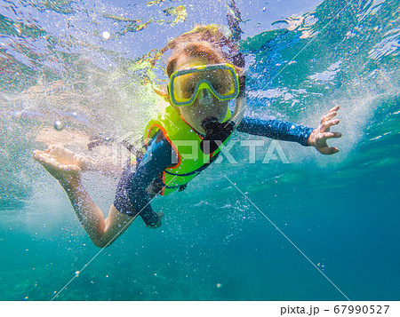 Child wearing snorkeling mask diving underwater 67990527