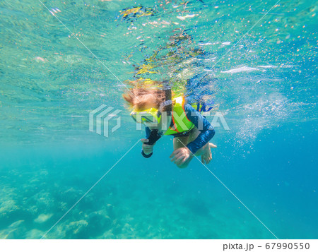 Child wearing snorkeling mask diving underwater 67990550