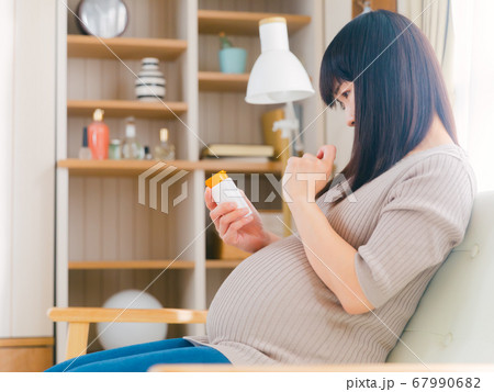 サプリメントを摂取する妊婦　考える　悩む　注意　コピースペース　4:3 67990682