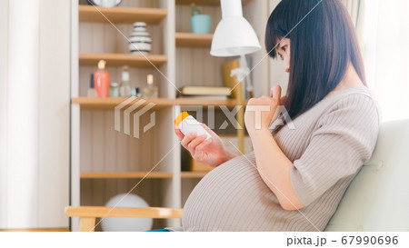 サプリメントを摂取する妊婦　考える　悩む　注意　コピースペース　16:9 67990696