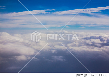 Aerial sky and fluffy clouds background. View from airplane porthole Aerial sky and fluffy clouds background. View from airplane porthole 67991150