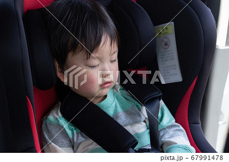チャイルドシートで寝る子供の写真素材