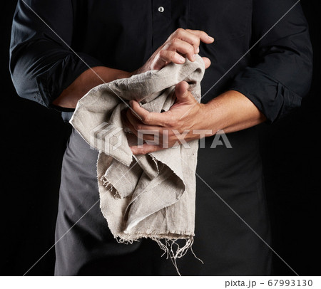man in black uniform holds gray linen rag and man in black uniform holds gray linen rag and 67993130