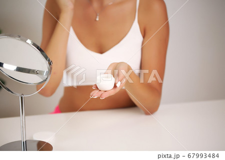 Young woman in a bathrobe, brings beauty in the bathroom Young woman in a bathrobe, brings beauty in the bathroom 67993484