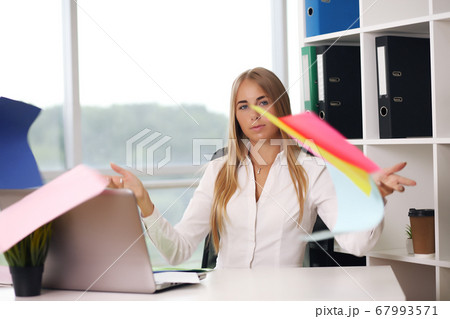 blonde throws paper woman in office, business concept blonde throws paper woman in office, business concept 67993571