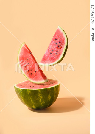 Sliced watermelon flying under beige background. Sliced watermelon flying under beige background. 67995071