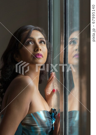 窓辺に立つ、若い女性 67995140