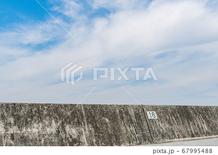 堤防から見える青空と雲 干拓の海の堤防の奥に晴天の空の写真素材