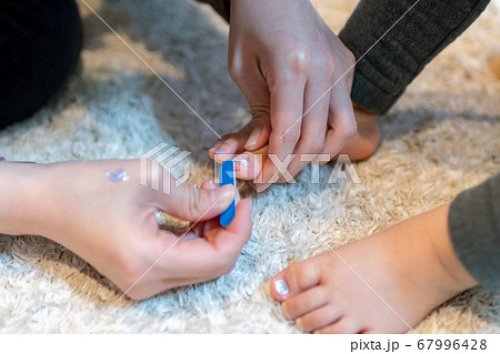 女の子の足にネールシールを張る姿 子供の足 女の子の足にネールシールを張る姿 子供の足 67996428