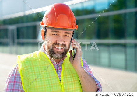 inspector in construction helmet answer phone call inspector in construction helmet answer phone call 67997210