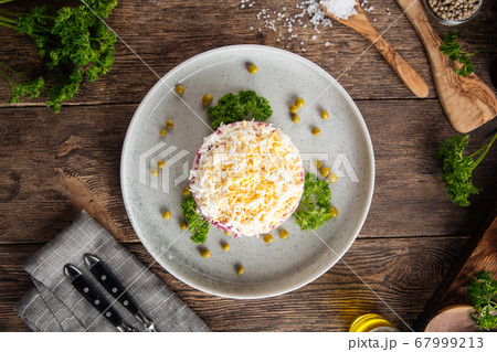 Top view on layer russian salad herring under coat 67999213