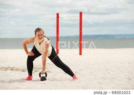 Portrait of positive woman wearing top and leggings warming up. Portrait of positive woman wearing top and leggings warming up. 68001022