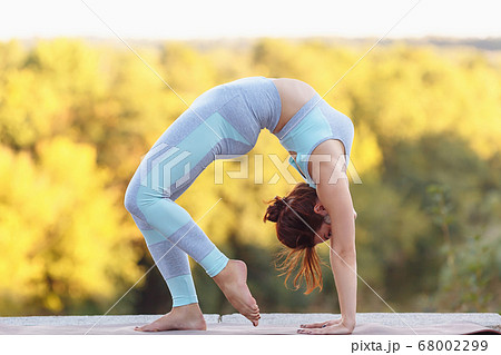 Pretty young sexy woman doing yoga exercises in the park Pretty young sexy woman doing yoga exercises in the park 68002299