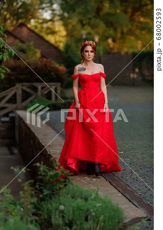 Attractive redhead tattooed woman in red dress and 68002593
