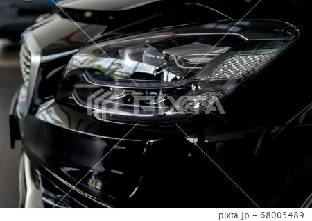 Close-up image of headlights of black premium car 68005489