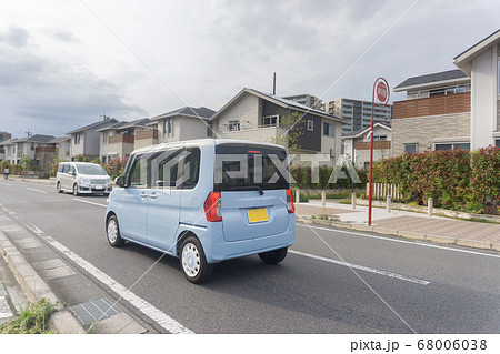 閑静な住宅地に走る軽乗用車 68006038