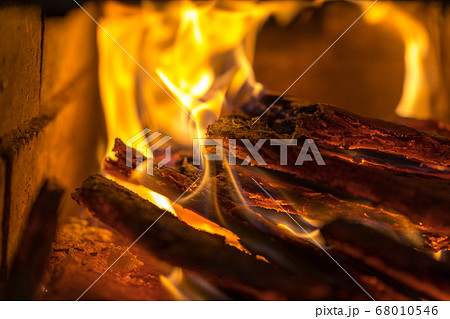 Flame incinerates firewood and transforms it ashes, close up, shallow depth of field. Blaze in a large stove. Nature texture of fire. The flame of fire burns in the brazier, smoldering firewoods. Flame incinerates firewood and transforms it ashes, close up, shallow depth of field. Blaze in a large stove. Nature texture of fire. The flame of fire burns in the brazier, smoldering firewoods. 68010546