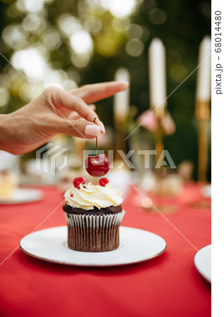 Table setting, woman decorate cake with cherry Table setting, woman decorate cake with cherry 68014480