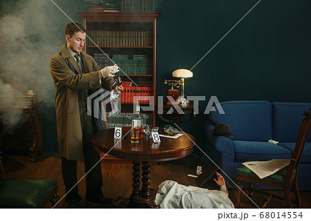 Male detective puts murder weapon in a bag 68014554