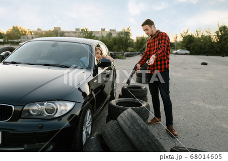 Sad student against downed tires, driving school 68014605