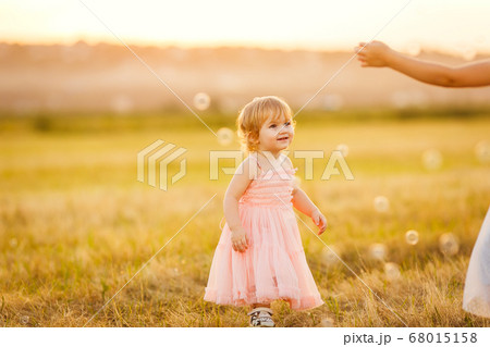 little girl chasing soap bubbles on sunset little girl chasing soap bubbles on sunset 68015158