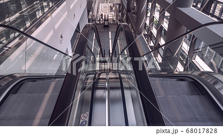 Grey and black moving escalator in interior of office building 68017828