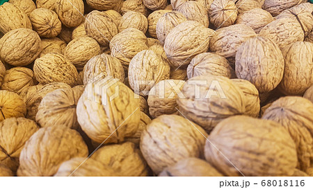 lots of brown inshell walnuts texture at the fresh vegan market 68018116