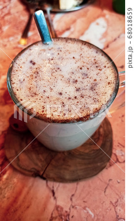 Turkish traditional winter drink salep with cinnemon powder into the glass cup on the marble table 68018659