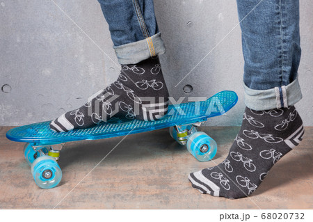 male legs in gray socks, on a blue skateboard, the male legs in gray socks, on a blue skateboard, the 68020732