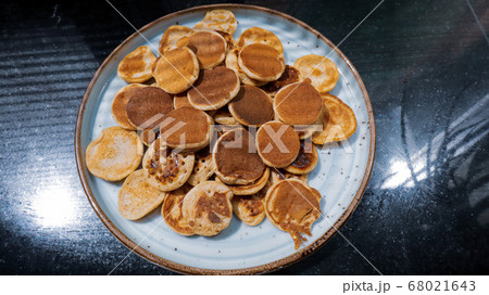 A plate of Dutch Mini Pancakes, poffertjes with peanut butter on the wooden background 68021643