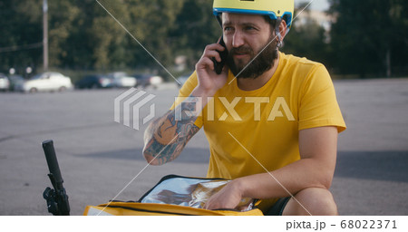 Delivery man searching in his backpack Delivery man searching in his backpack 68022371