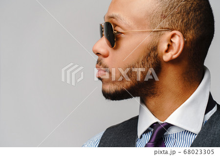 African-American businessmanman wearing glasses portrait over grey background African-American businessmanman wearing glasses portrait over grey background 68023305