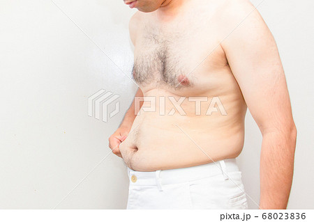 中年太りの男性の上半身　下腹をつまんでいる肥満の男性 68023836