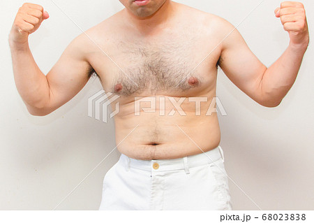 中年太りの男性の上半身 筋肉を見せる毛深い男性の写真素材
