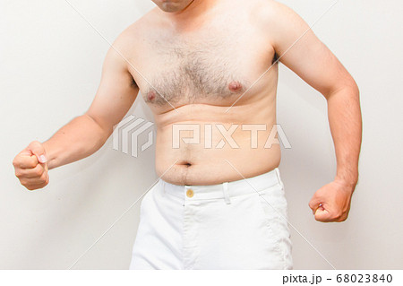 中年太りの男性の上半身 拳を握り締める毛深い男性の写真素材