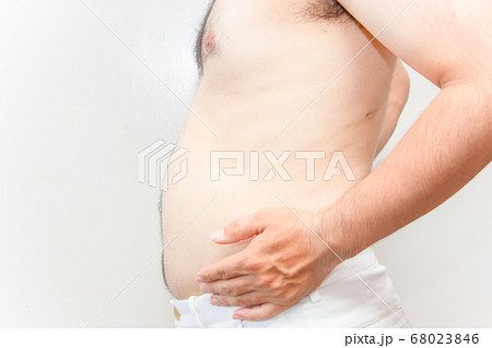 中年太りの男性の上半身　下腹を抱える毛深い男性 68023846
