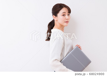 オフィスで働くビジネスウーマン(ノートPCを持つ女性) オフィスで働くビジネスウーマン(ノートPCを持つ女性) 68024900