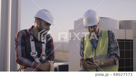 Engineers having a break on a cell tower Engineers having a break on a cell tower 68027573