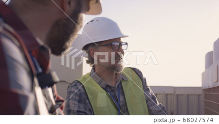 Engineers having a break on a cell tower Engineers having a break on a cell tower 68027574